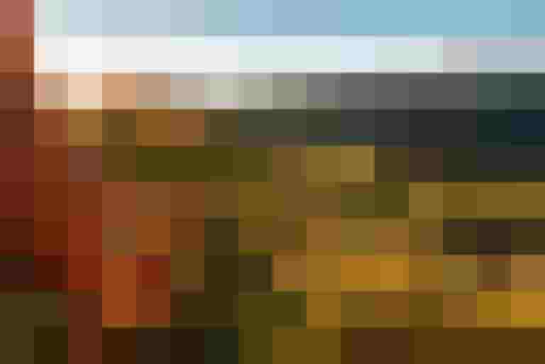 Wanderer entspannen auf einer Wiese mit Bergpanorama und Sonnenstrahlen im Hintergrund.